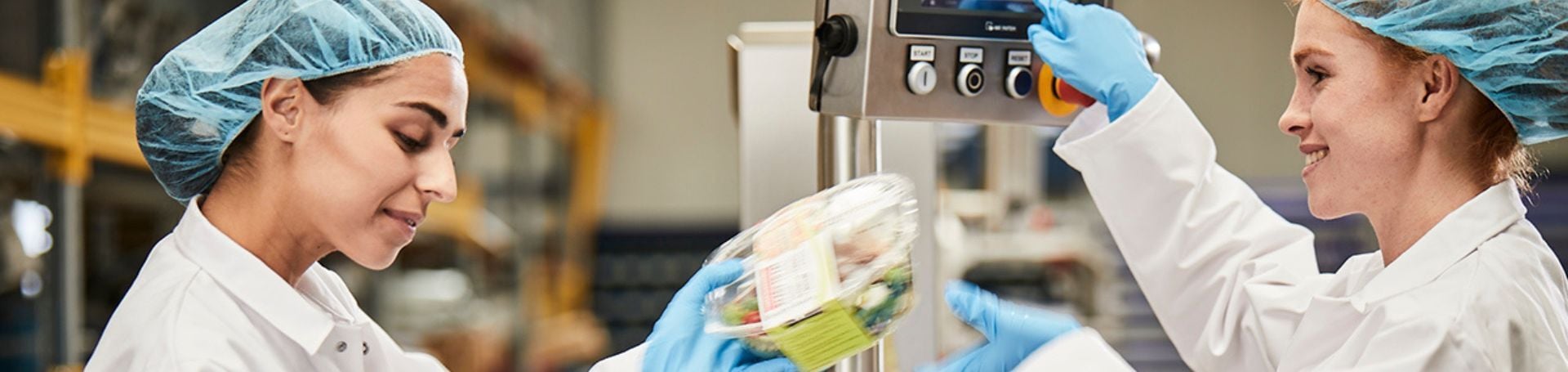 Twee tevreden gebruikers werken met een JASA weeg- en verpakkingsmachine in een productieomgeving