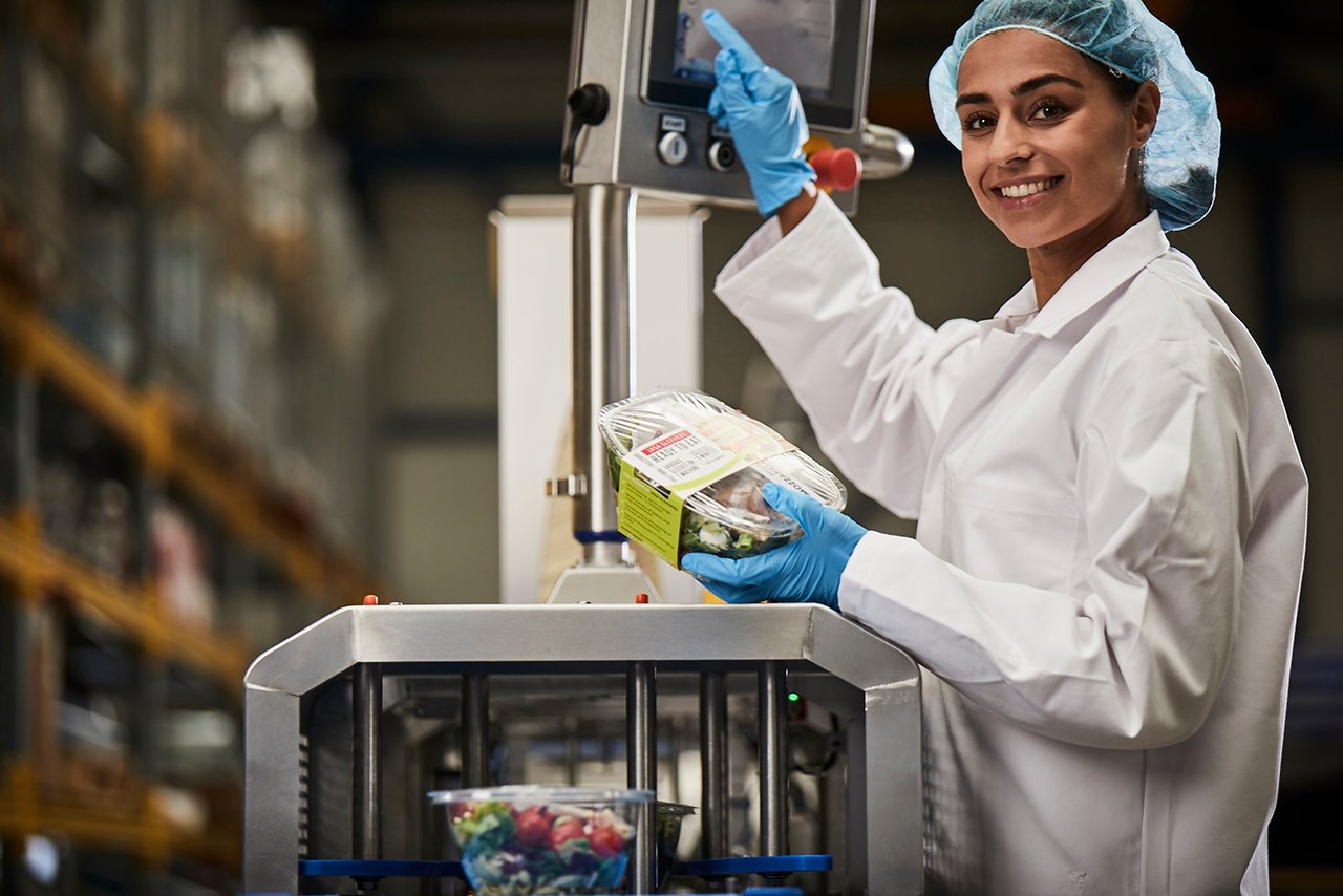 Operator using JASA Sleever for tray packaging of fresh food products